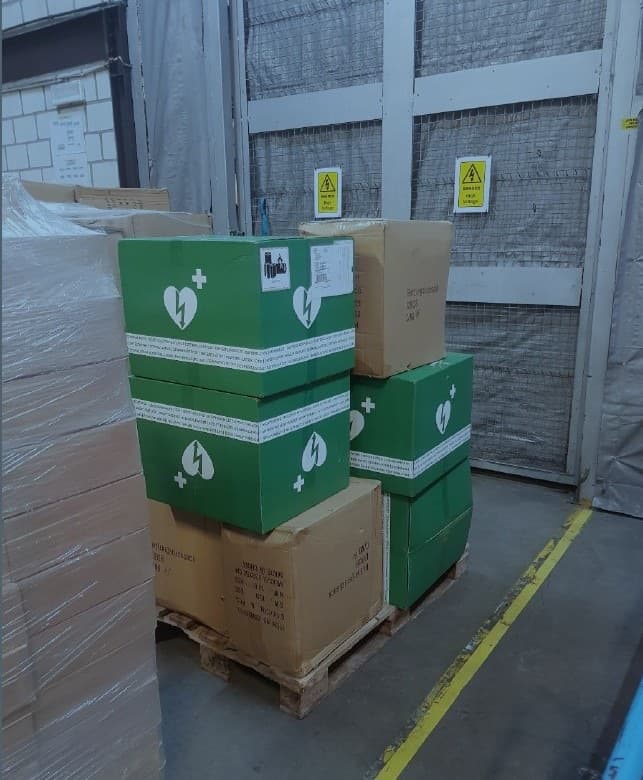 Cartons de défibrillateurs sur une palette en entrepôt